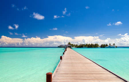 footbridge over turquoise ocean on an maldivian islandの写真素材
