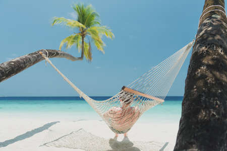teen boy in beach hammock on the maldivesの写真素材