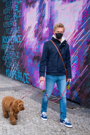 Man walks dog wearing face mask protectionの写真素材