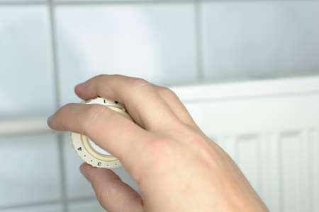 Close-up Of A Man's Hand Adjusting from radiatorの写真素材