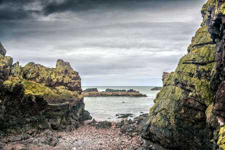 Dunbar green cliffs with gray-blue sky at the seaside and Castle 'Ruins'. a view of East Lothian. Scotlandの写真素材