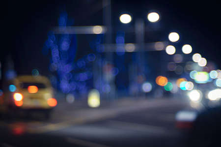 Evening traffic. The city lights. Motion blur and bokeh effect viewed from the road