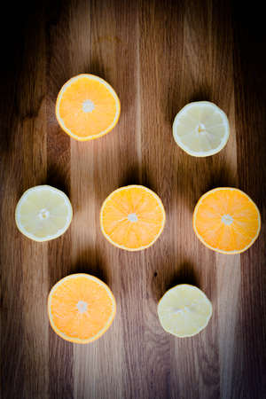 Citrus fruit cut in half - oranges, lemons, tangerines on a wooden backgroundの写真素材