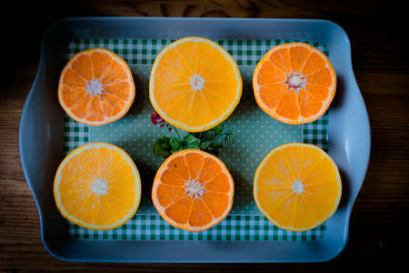 Citrus fruit cut in half - oranges, lemons, tangerines on a wooden background