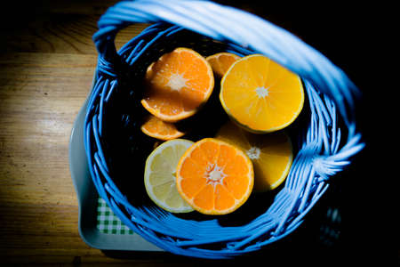 Citrus fruit cut in half - oranges, lemons, tangerines on a wooden backgroundの写真素材