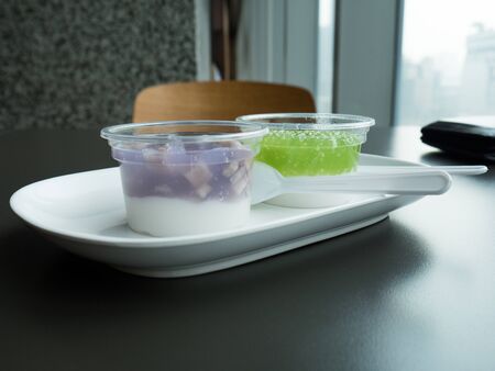 Thai pudding with coconut topping in plastic cupの写真素材