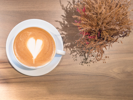 Hot coffee in white cup on wooden tableの写真素材