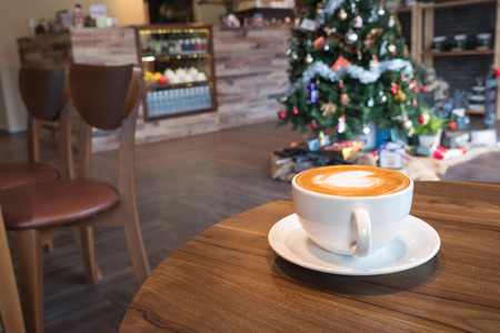Delicious hot coffee in white cup on wooden tableの写真素材