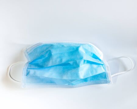 surgical face mask with rubber ear straps for protection against germs on white background