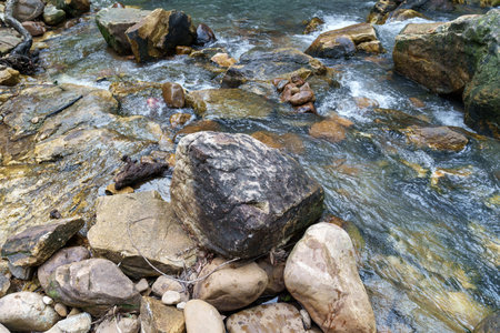 A serene river scene featuring smooth rocks and flowing water, creating peaceful atmosphere