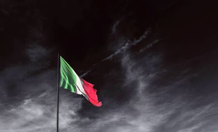 Italian flag in a dark sky, the emergency does not turn off the colors of the flagの写真素材