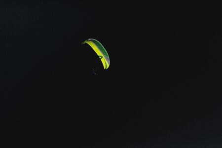 Sign of freedom on a dark background, green parachuteの写真素材