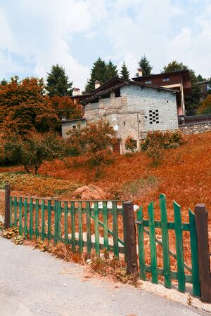 Alpine landscape in autumn, old barn behind a wooden fenceの写真素材