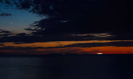 Sunset behind Capraia island on Mediterranean sea in summer time, Italyの写真素材