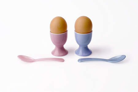 two brown eggs in eggs cups and spoons - breakfast