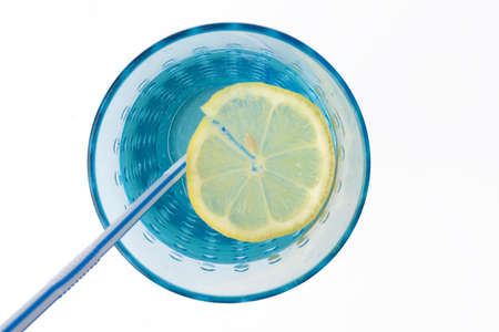 glass of mineral water with lemon and straw on white backgroundの写真素材