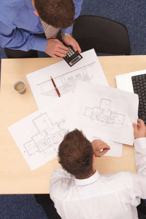 Aerial view of two businessmen calculating the plans.