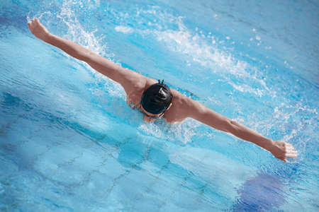Swimmer in cap performing the butterfly strokeの写真素材