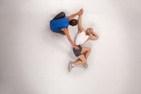athletic man stretching with personal trainer athletic man stretching with personal trainer