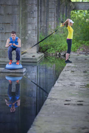 Couple exercising outdoor  sporty man and woman training on fresh air の写真素材