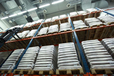 Sacks on wooden pallets on shelves  inside storehouse