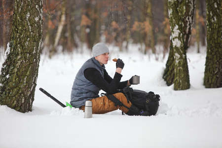 winter hiker having break for sandwich and cup of teaの写真素材