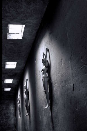 three resting people - mannequins lying in dark room on the floor in sunlightの写真素材