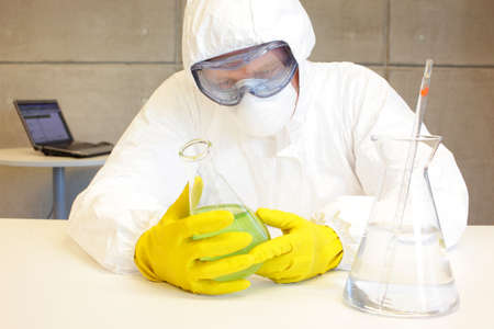technician in protective uniform working  in lab