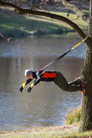 suspension workout at the river - man at the outdoor training at the riverの写真素材