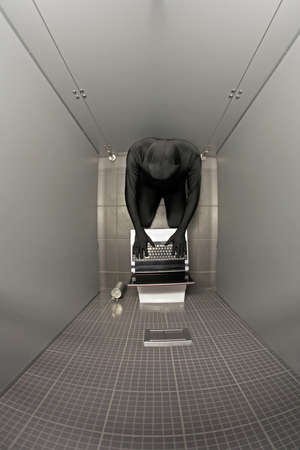 overhead view of anonymous person in black suit working on laptop in toiletの写真素材