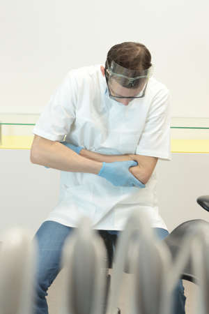 Dentist suffering from elbow pain -occupational diseaseの写真素材