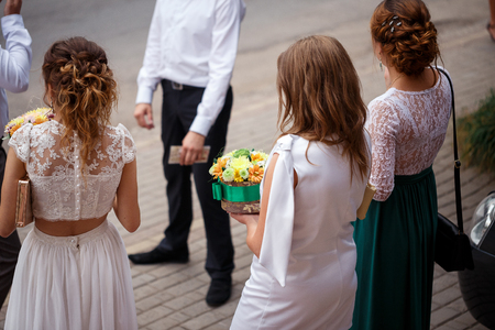 young girls standing in the street and holding flowersの写真素材