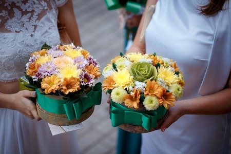 Girls in white dresses holding two boxes of flowers