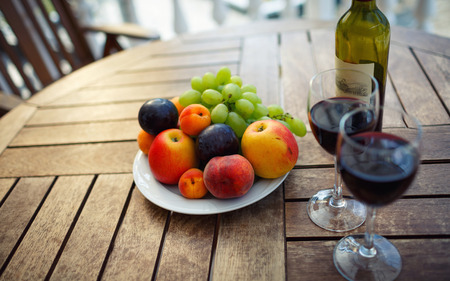 red wine, fruit and wine on the table prepared for a romantic dateの写真素材