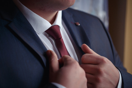 A man in a blue suit with a white shirt and maroon tieの写真素材