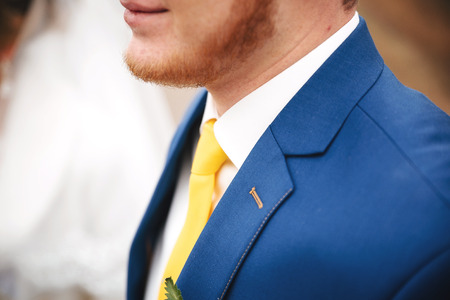 wedding stylish blue suit with a yellow tie and yellow flowerの写真素材