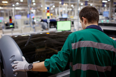 Worker in green uniform working in manufacturing