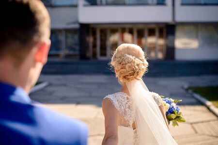 The bride turned with her back leading the groom's hand to the wedding hall