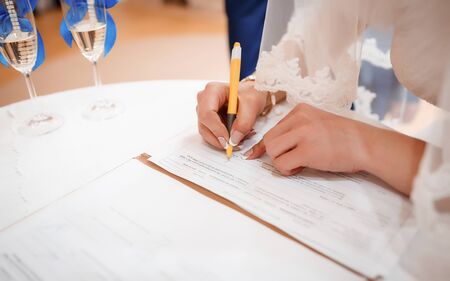 Bride puts signature in the registry office