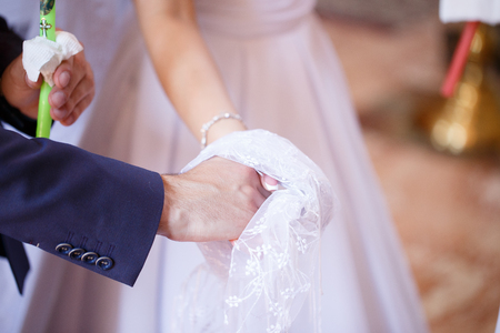 Wedding couple holding candles at the wedding ceremony in the Christian churchの写真素材