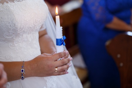 Wedding couple holding candles at the wedding ceremony in the Christian churchの写真素材