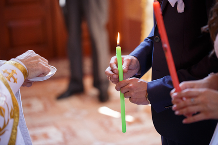 Wedding couple holding candles at the wedding ceremony in the Christian churchの写真素材