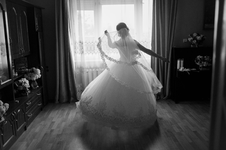 bride standing at the window and waiting for a loved oneの写真素材