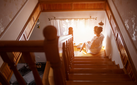 Bride in lingerie and sitting by the window waiting for her loverの写真素材