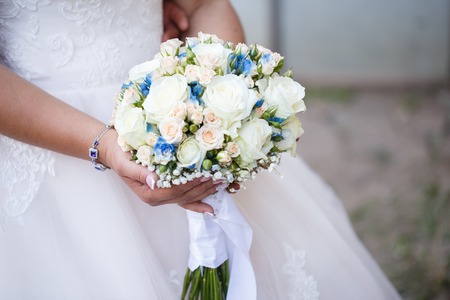 Bride in beautiful wedding dress holding a bouquet of white roses luxuryの写真素材