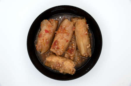 A dish of cabbage rolls in a black plate, which is minced meat with boiled rice, wrapped in cabbage...