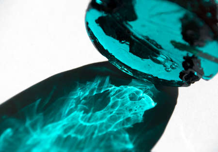 Lollipop with black currant berries inside a turquoise color on a white background.の写真素材