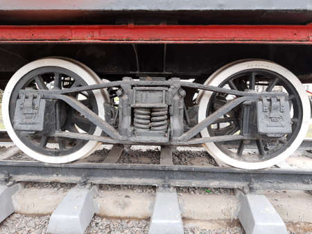 Wheels of an old steam locomotive on rails close-up.