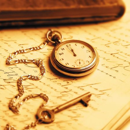 old pocket watch and key over notebookの写真素材