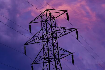 electric tower silhoutte against a cloudy sky